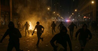 Crowd of masked individuals in a city street at night with broken windows and fires, depicting unrest and looting.
